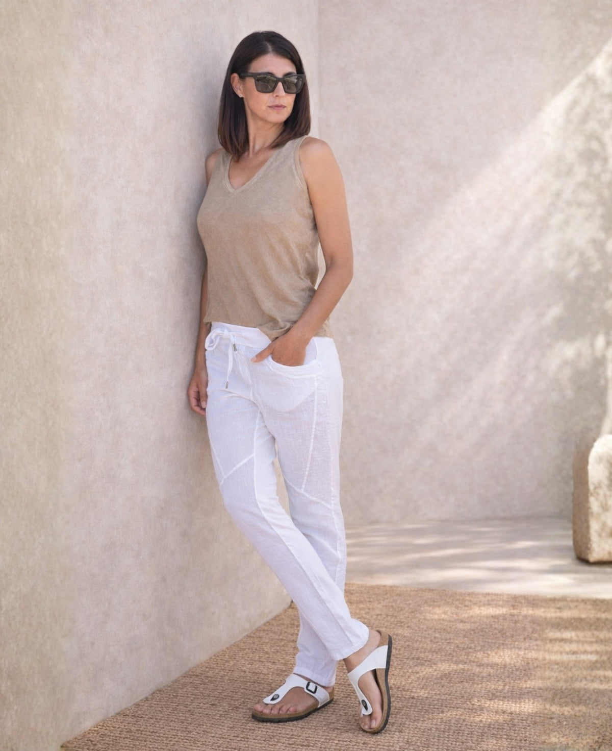 Full body side view of the Jordan Linen Pants in white highlighting the soft jersey back panel and front seam detail.