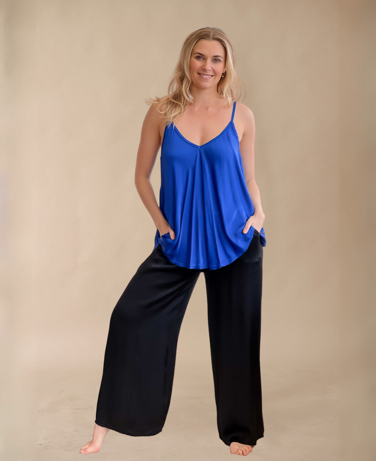 Timeless black satin wide-leg pants featuring a sleek drape, elastic waistband, and functional side pockets. A must-have for versatile, effortless sophistication.
