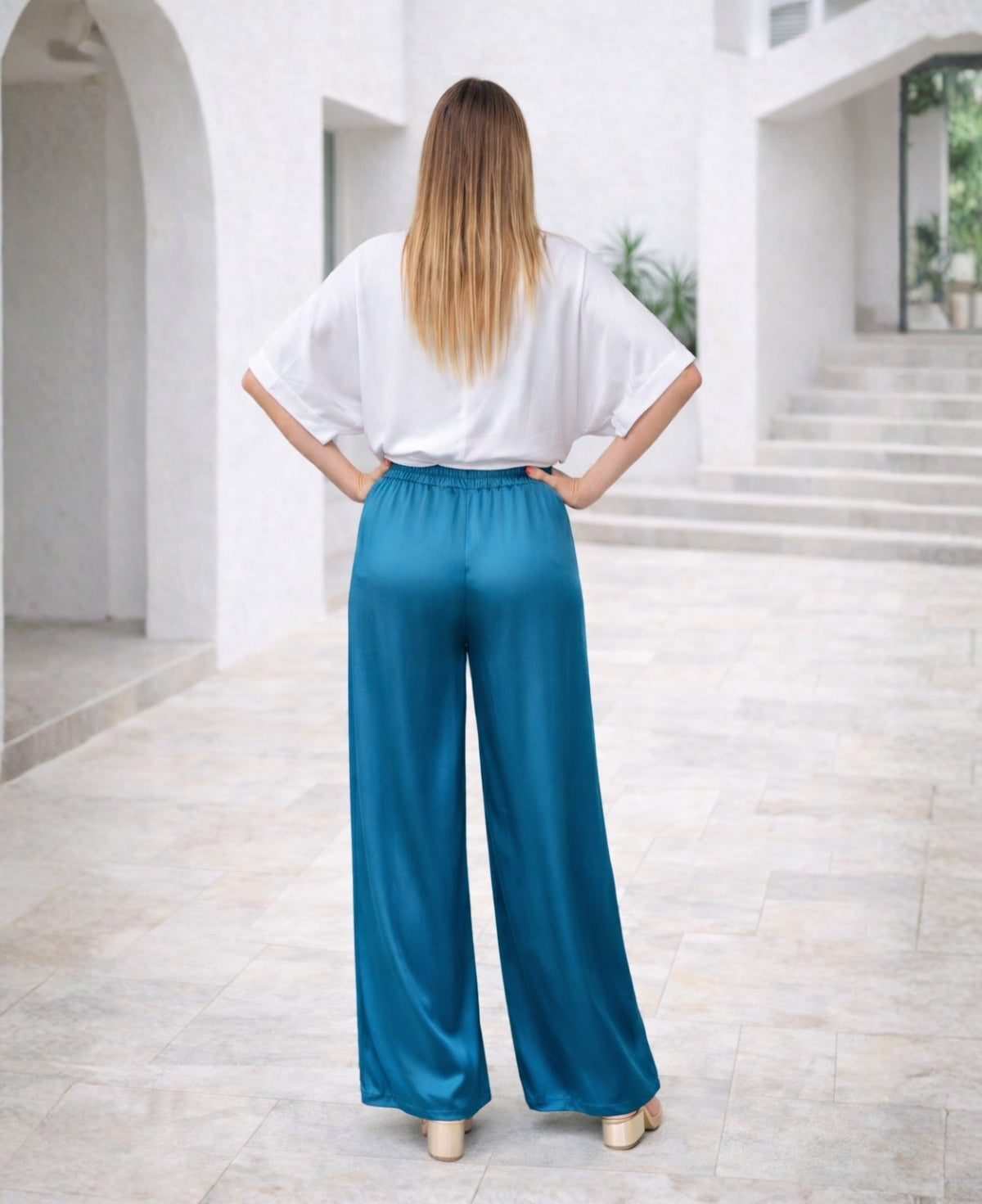 Luxurious satin wide-leg pants in deep blue teal, designed with a flowing silhouette, elastic waistband, and side pockets. A stylish and sophisticated choice for any occasion