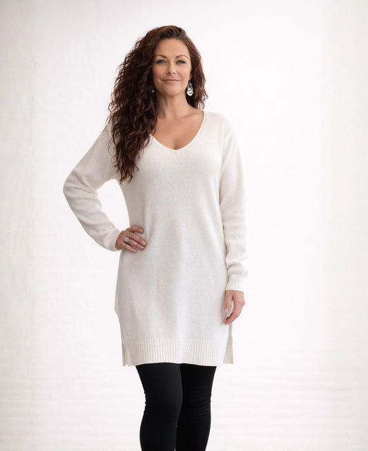 Ivory long cashmere sweater with V-neck and side splits worn by model, front view