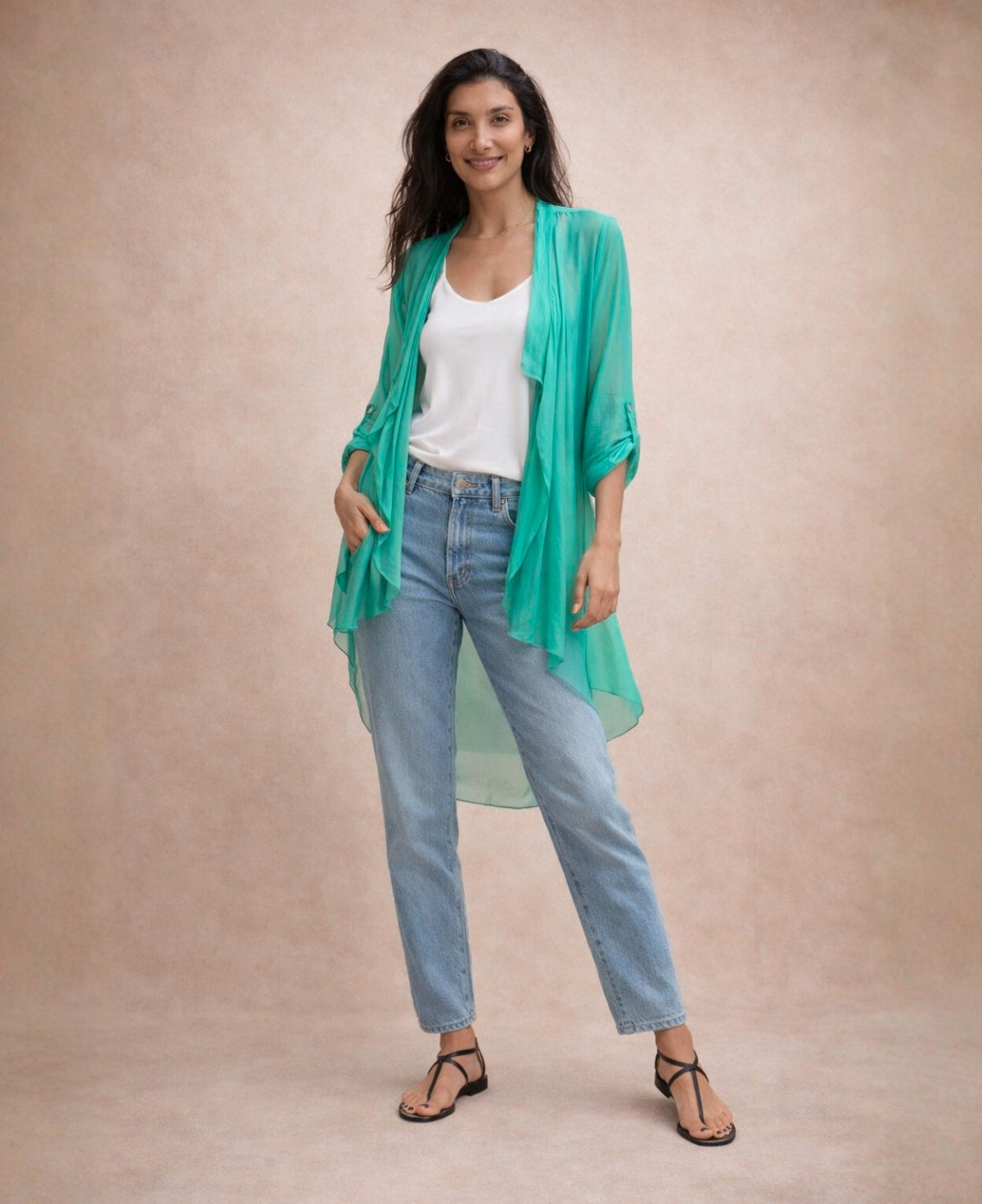 Emerald green Katherine Sheer Silk Overlay styled casually with a white tank and light-wash jeans, demonstrating everyday layering versatility in a neutral studio setting.