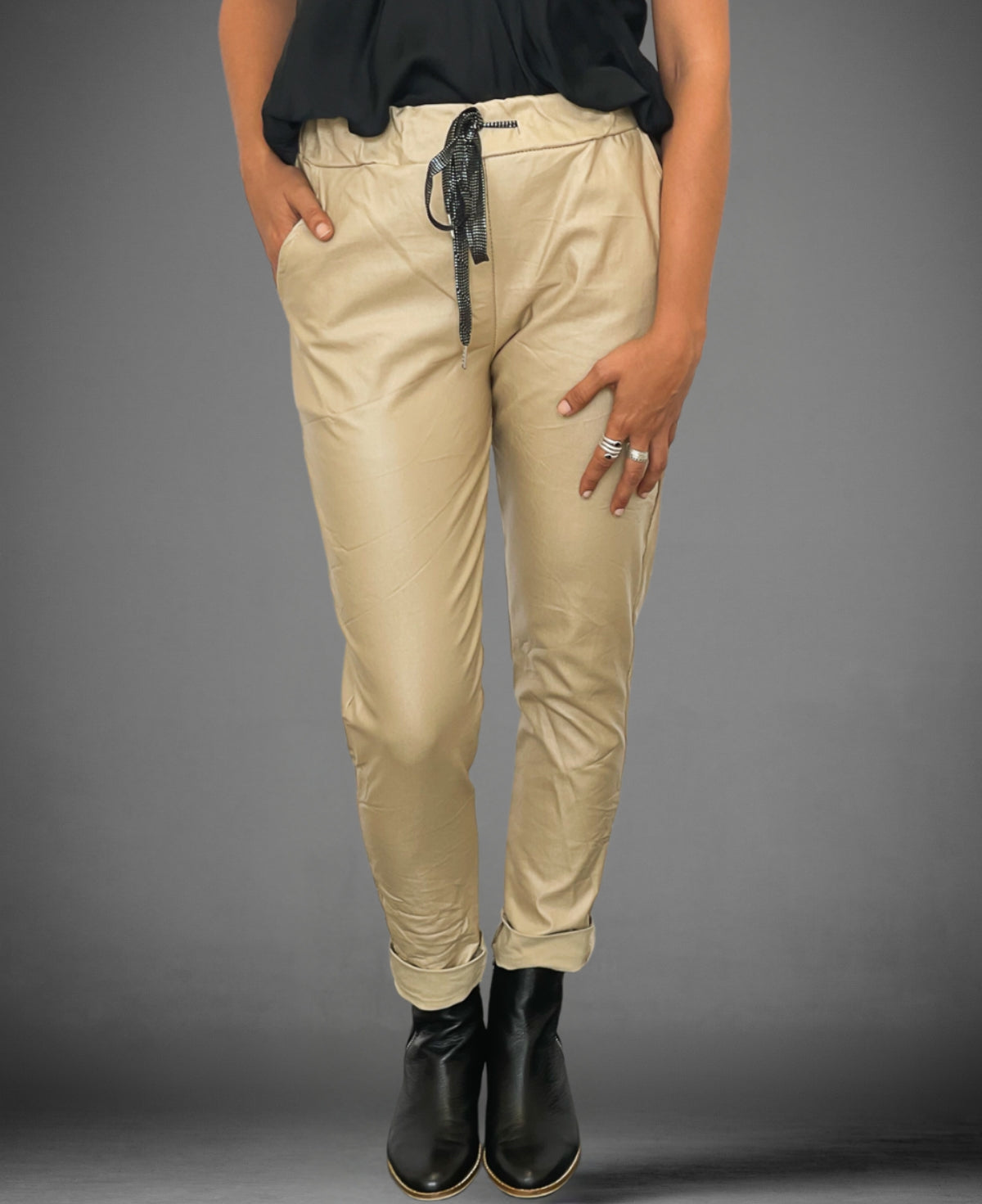 Close-up front view of blonde vegan leather pants, showcasing the ribbed waistband and drawstring detail.
