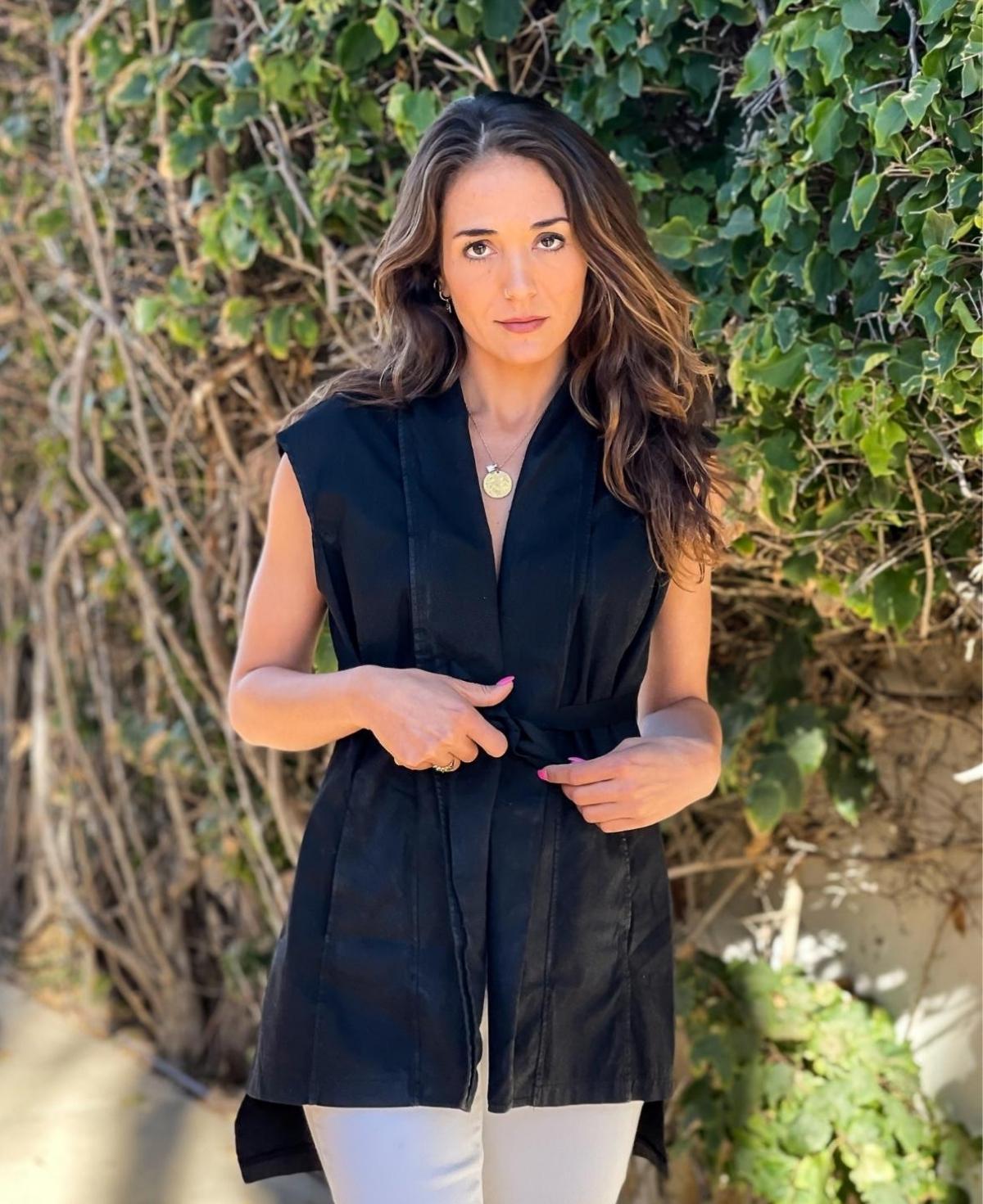 Fashion-forward black Leia Vest showcasing a modern tie-up waist and exclusive waxed-finish cotton construction for versatile layering.