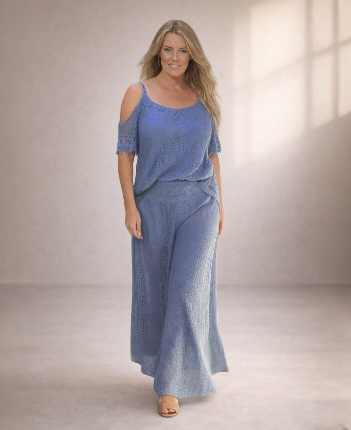 Model wearing Louella Boho Lace Pants in Jeans blue, front view in minimalist studio with soft warm lighting.