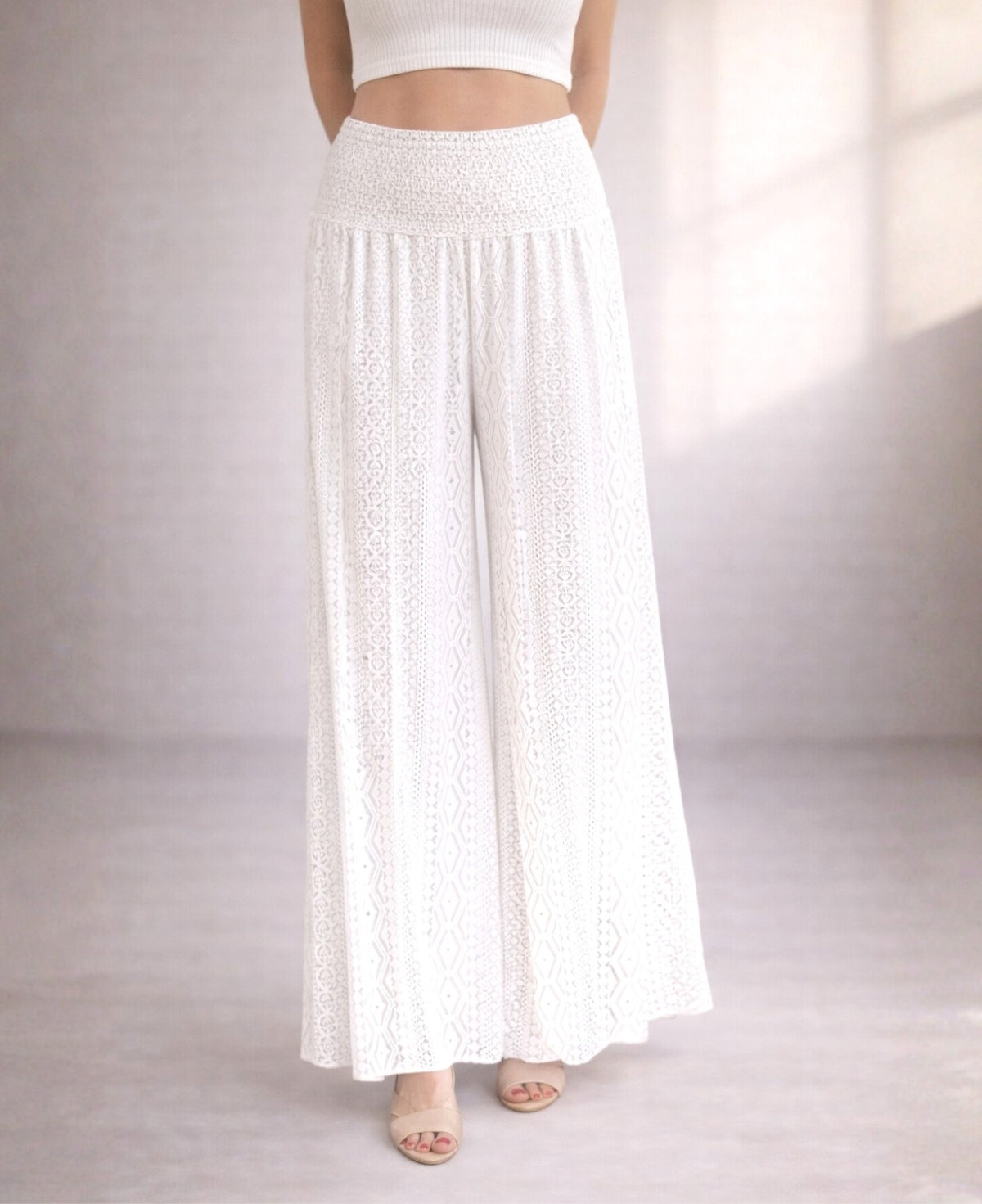 Waist-down studio image of Louella Boho Lace Pants in White showing shirred waistband and intricate lace pattern.