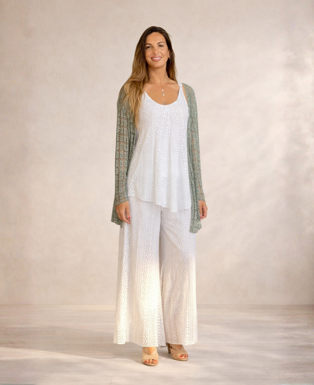 Full length studio image of Louella Lace Cardi in Khaki worn over white lace outfit with relaxed silhouette.