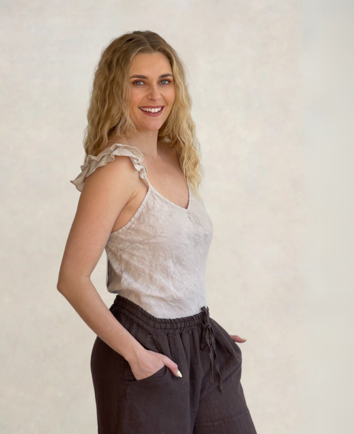 Oatmeal linen cami with ruffle straps, bias-cut silhouette, and breathable 100% linen fabric. A timeless and elegant wardrobe essential.