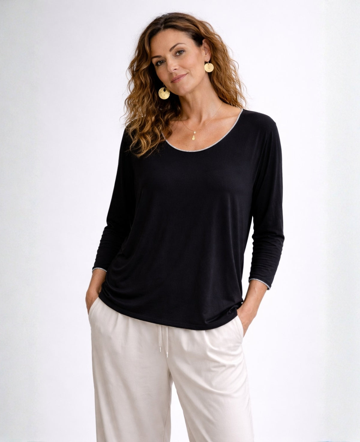 Woman wearing black Maree long sleeve viscose jersey top with scoop neckline and silver trim, front view