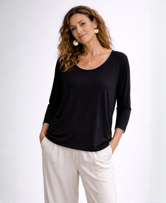 Woman wearing black Maree long sleeve viscose jersey top with scoop neckline and silver trim, front view
