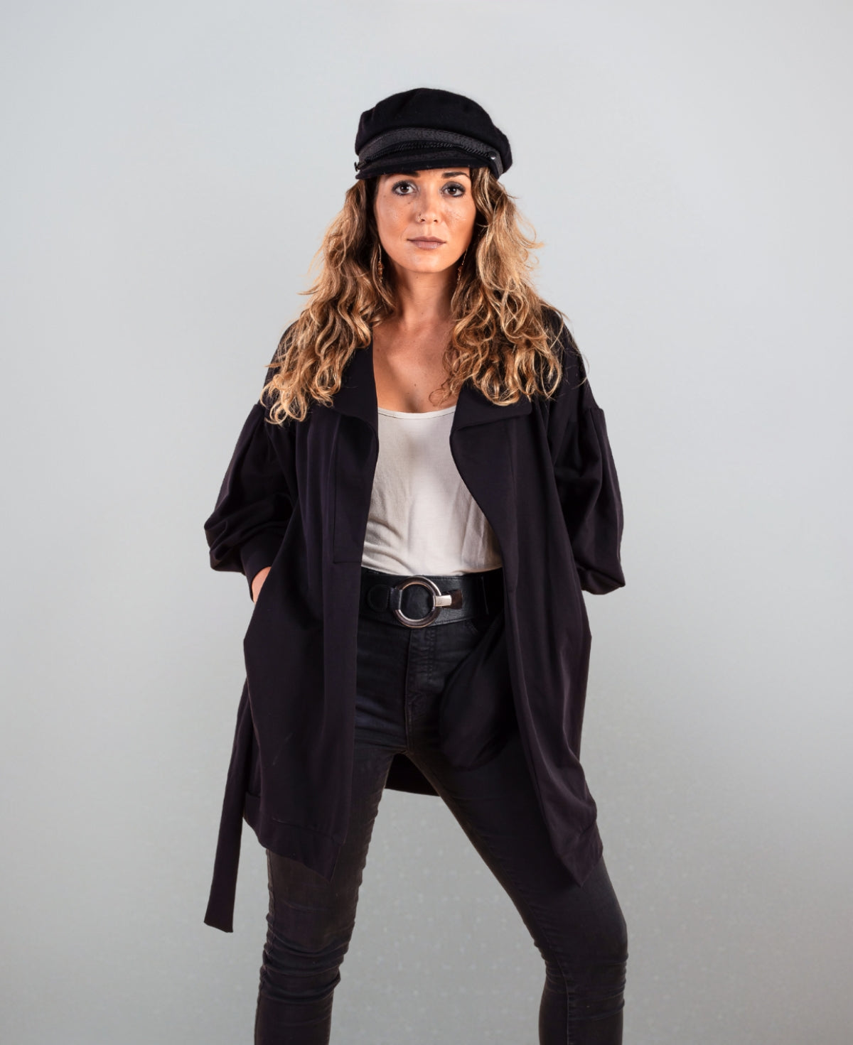 Black belted sweater coat with structured cuffs and puff sleeves for a modern, refined silhouette.
