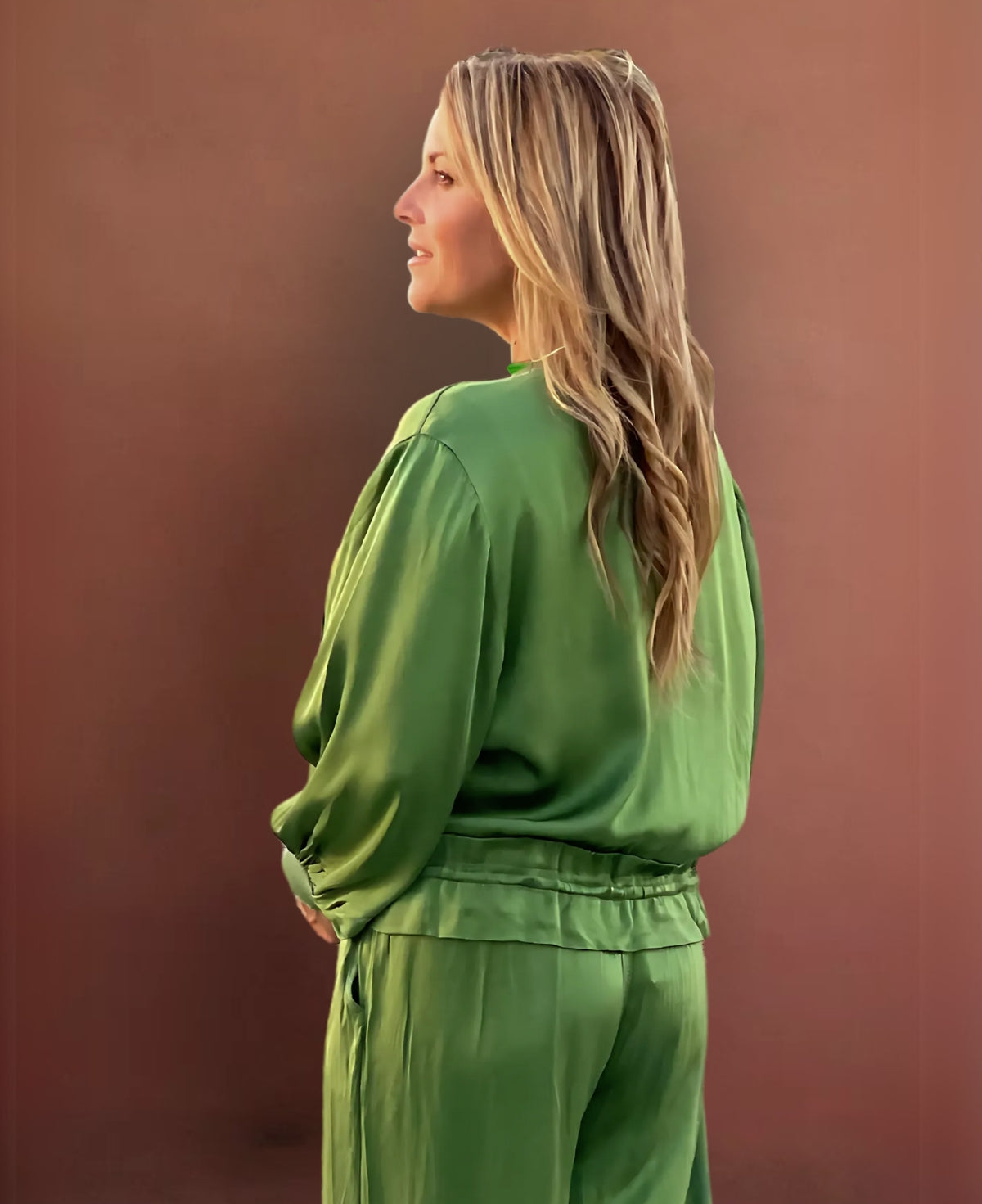 Vibrant apple green satin bomber jacket with ribbed knit details, a black gunmetal zipper, faux flap pockets, and an adjustable cinched waist for a striking, fashion-forward statement.