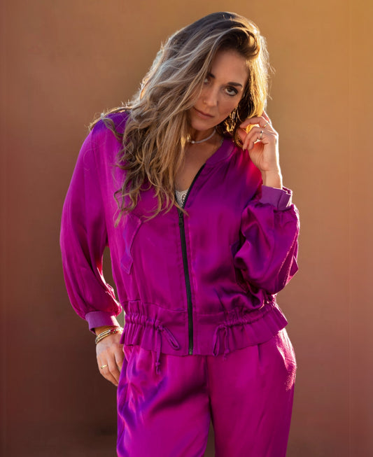 Chic sangria satin bomber jacket with ribbed cuffs, a black gunmetal zipper, faux flap pockets, and an adjustable drawstring waist for effortless sophistication.