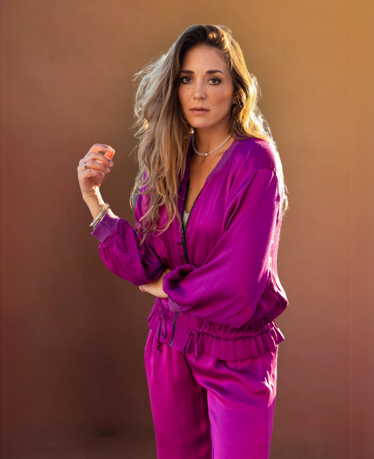 Chic sangria satin bomber jacket with ribbed cuffs, a black gunmetal zipper, faux flap pockets, and an adjustable drawstring waist for effortless sophistication.