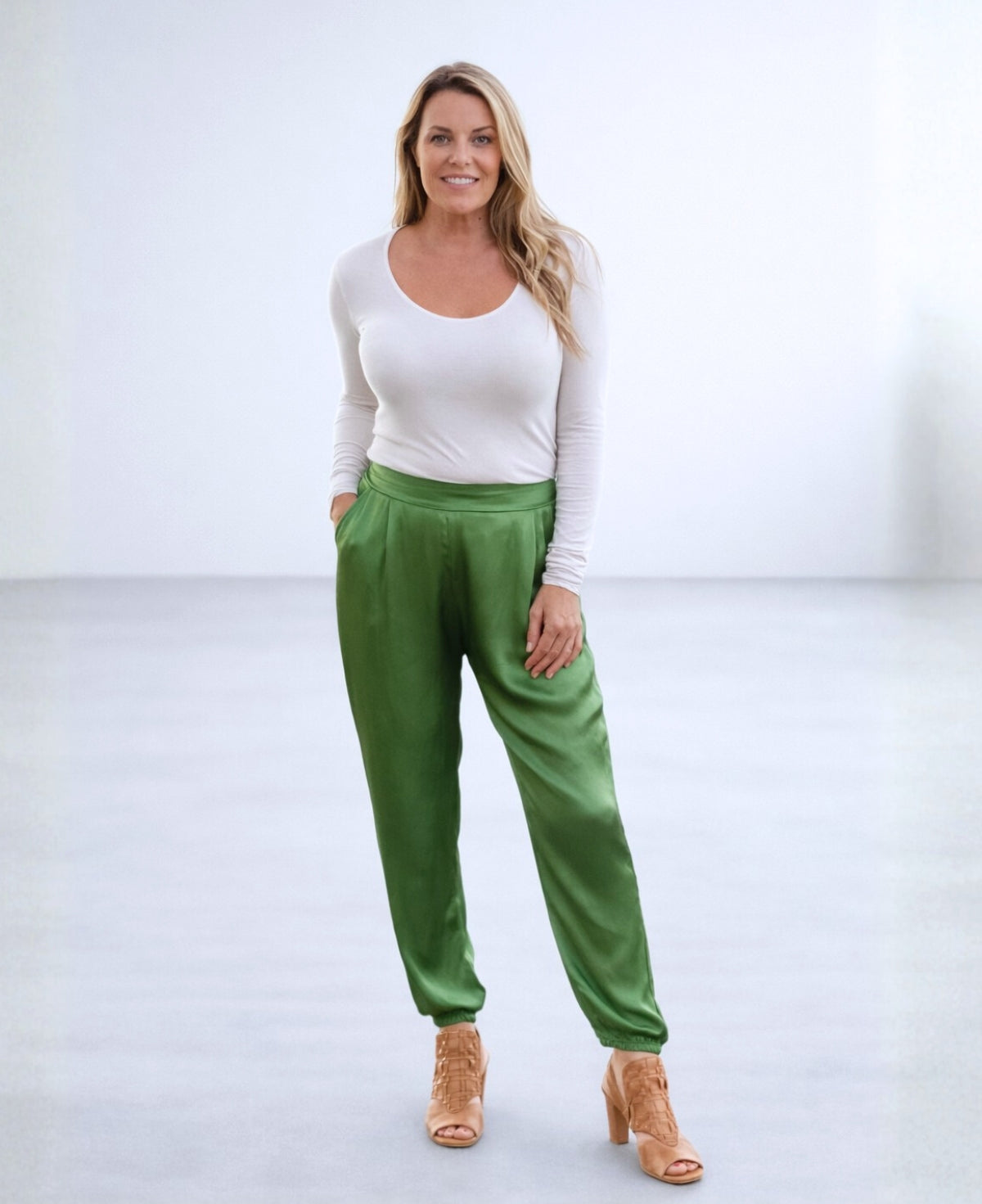 Front view of the Moulin Satin Joggers in Apple Green, featuring the smooth front waist, relaxed satin fit, side pockets, and gathered ankle cuffs.