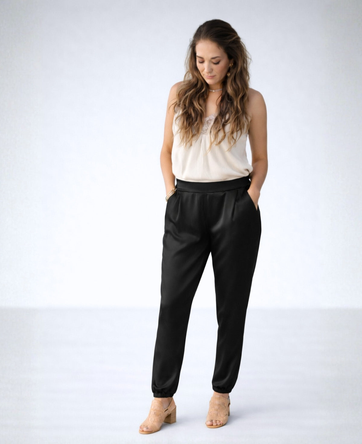 Front view of the Moulin Satin Joggers in Black, featuring the smooth front waist, relaxed satin fit, side pockets, and gathered ankle cuffs.