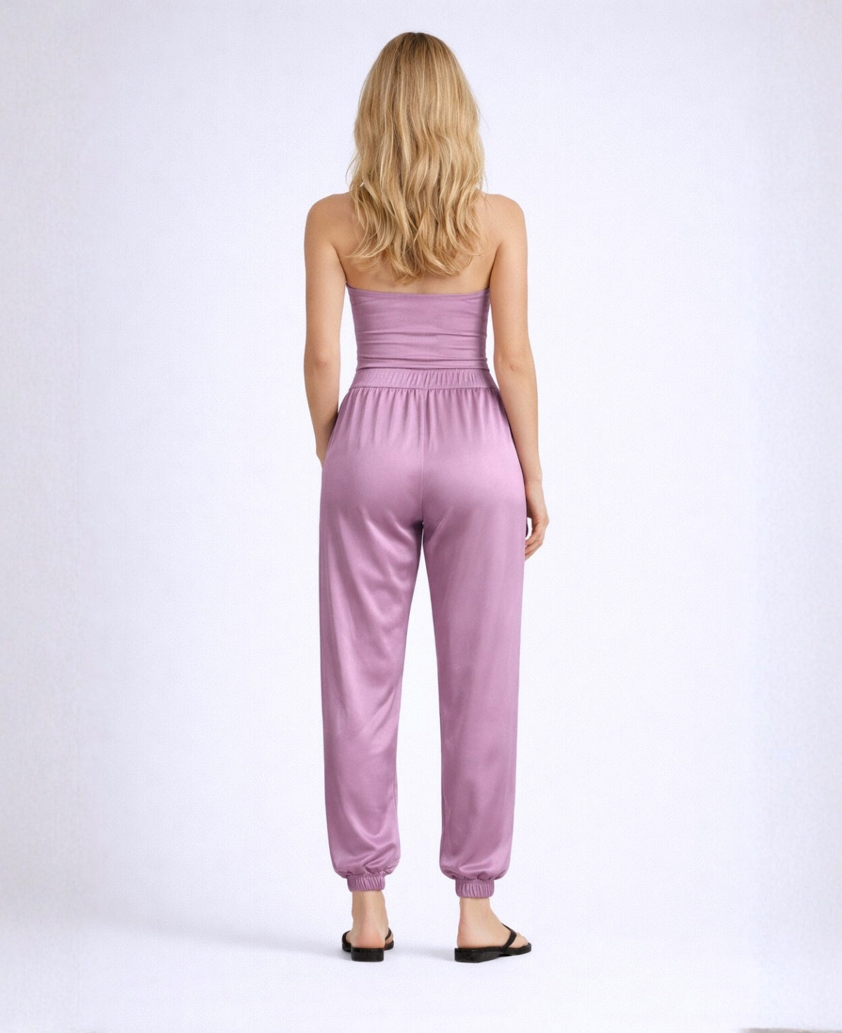 Back view of the Moulin Satin Joggers in Plum, showing the relaxed satin fit, elastic back waistband, gathered ankle cuffs, and soft drape through the legs.