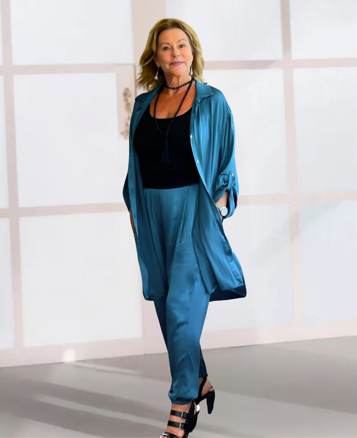 Sophisticated blue teal jogger pants with a flowing silhouette, gathered ankle design, elasticized back waistband, and convenient side pockets for a polished yet relaxed look.