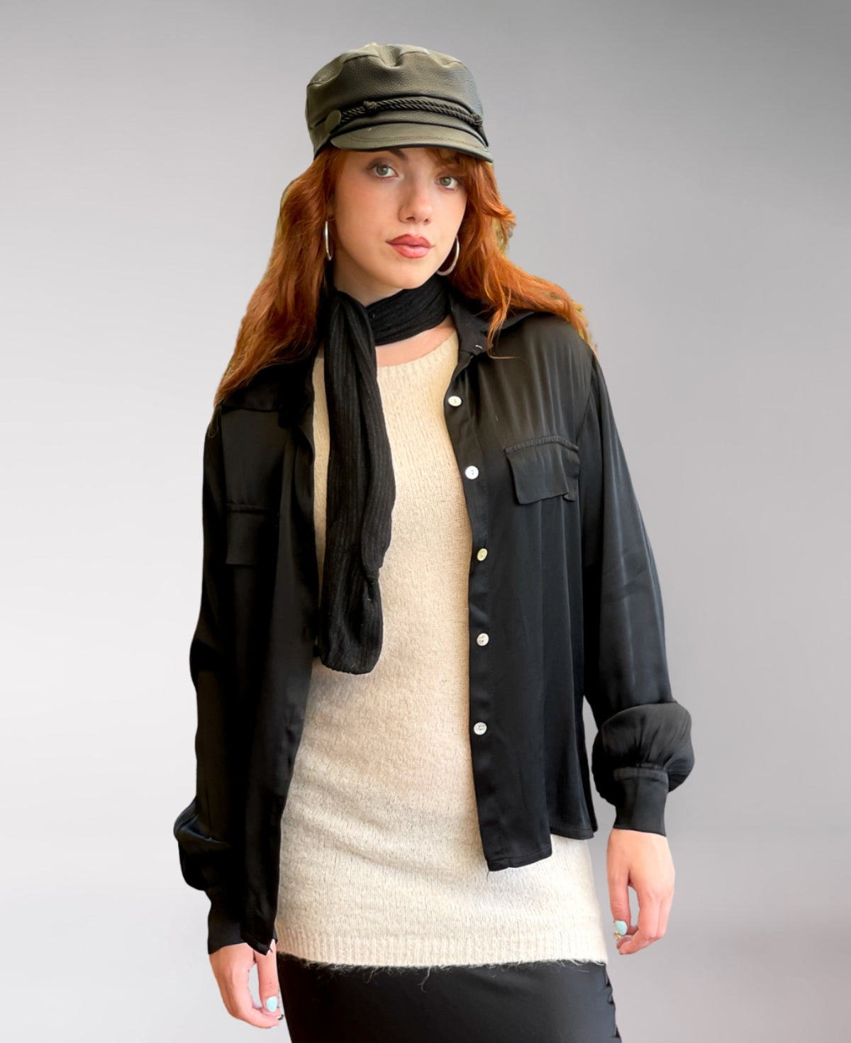 Timeless black satin button-up shirt with a structured collared neckline, front flap pockets, and buttoned cuffs. A chic and sophisticated must-have.