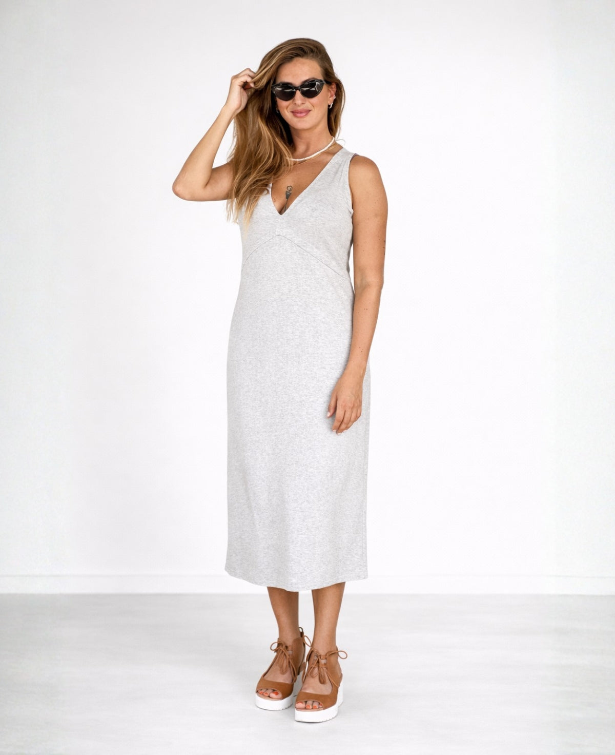Model wearing the Nell Knit Dress in sand grey colour, front view with sunglasses styled in clean studio setting.