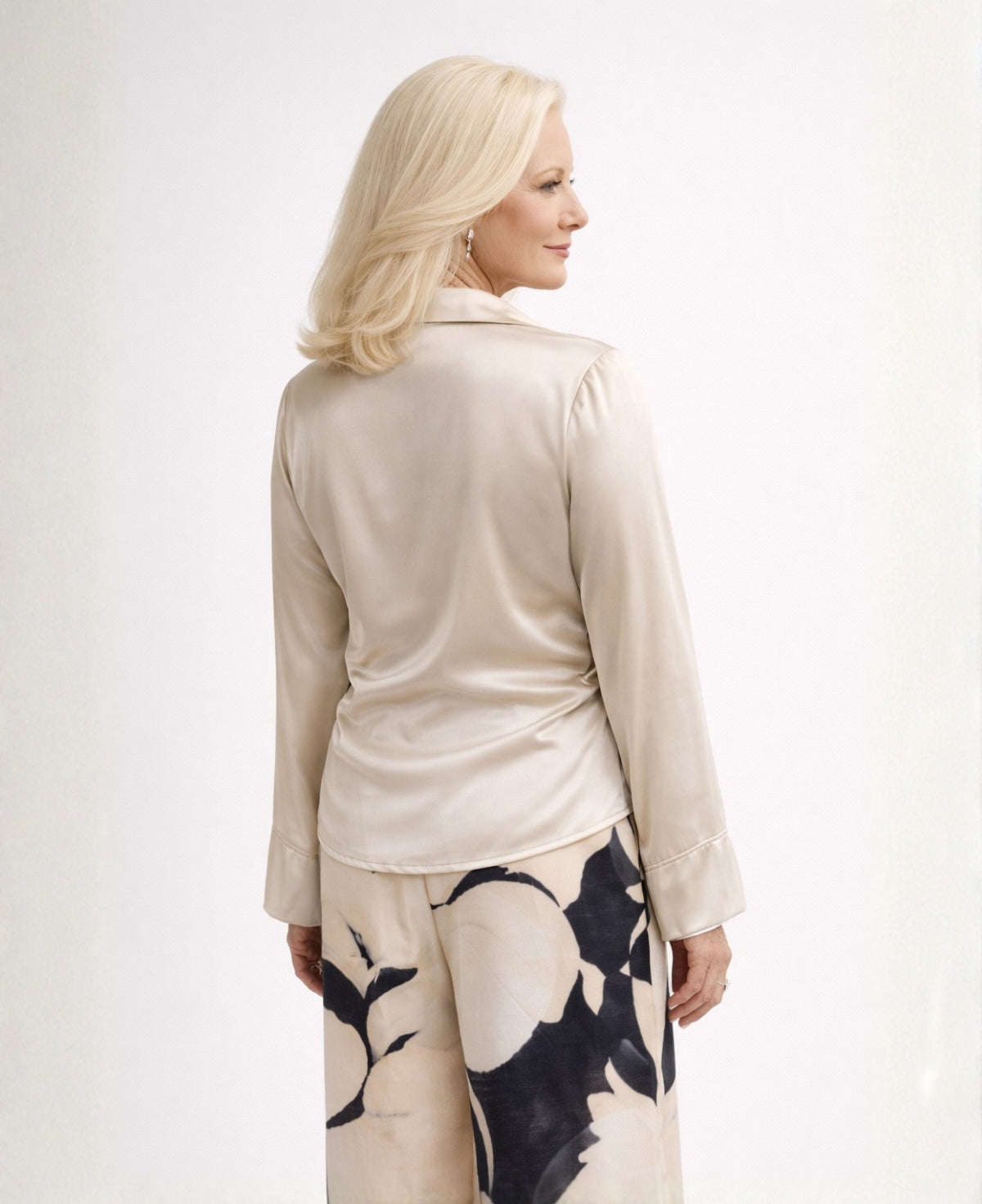 Back angled studio view of the oat Coral satin blouse, highlighting the smooth back panel, relaxed sleeves, and soft satin drape.