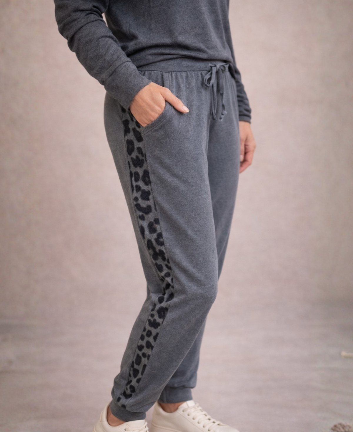 Close side view of Paris Knit Jogger pants in grey showing leopard stripe detail and pocket