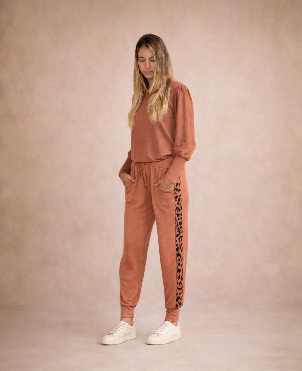 Model wearing Paris Knit Jogger pants in rust angled view highlighting leopard stripe panel