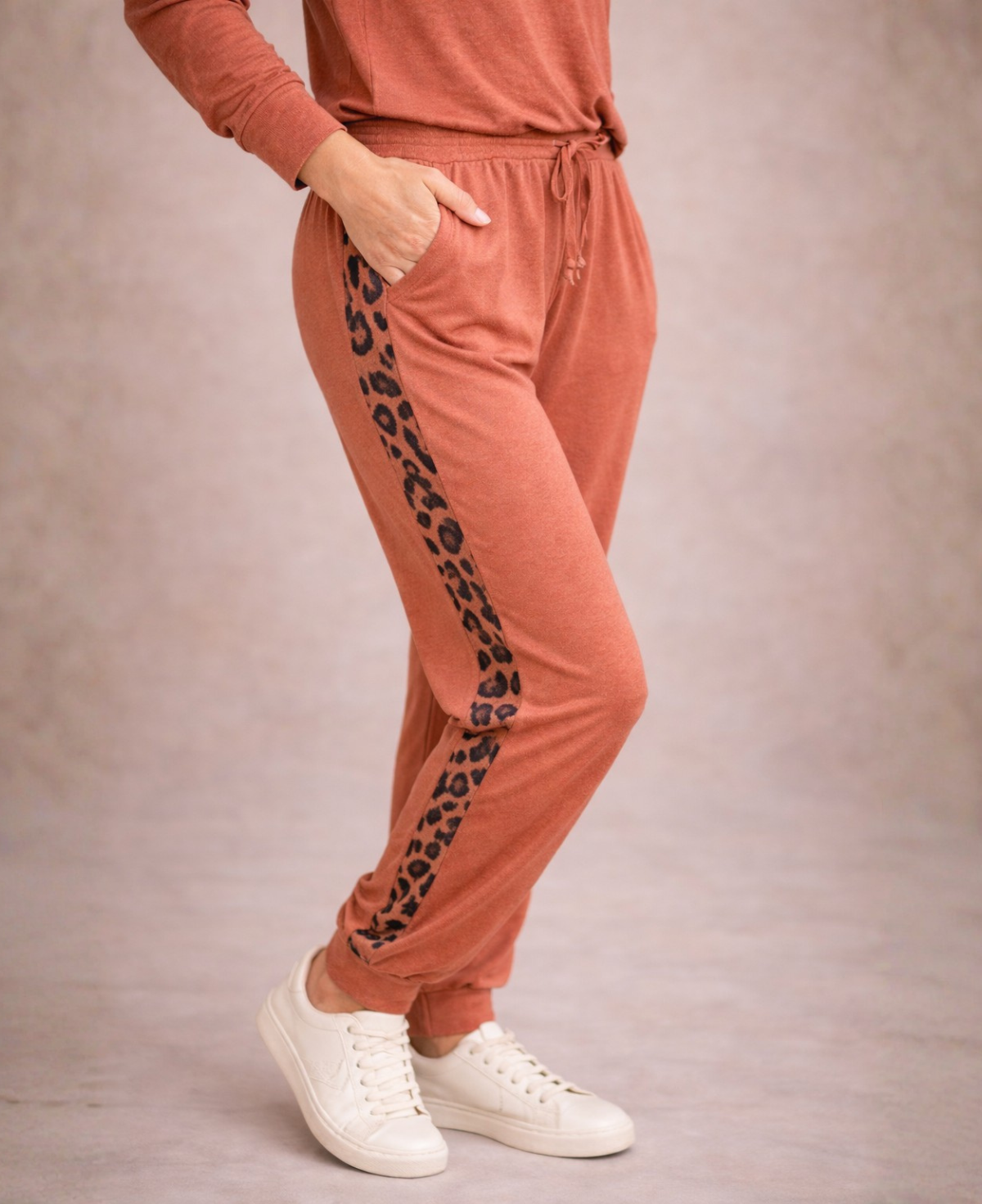 Close view of Paris Knit Jogger pants in rust colour with leopard stripe side panel and pocket detail
