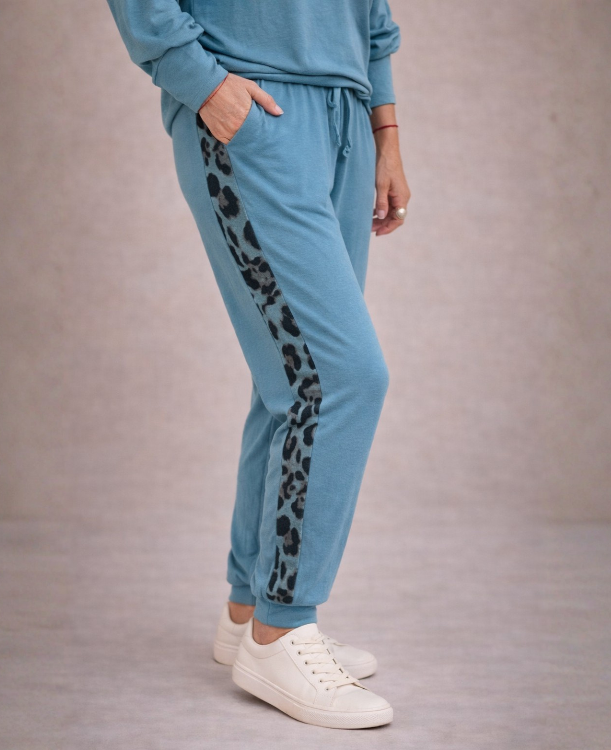 Close side view of Paris Knit Jogger pants in teal showing leopard stripe detail and side pocket