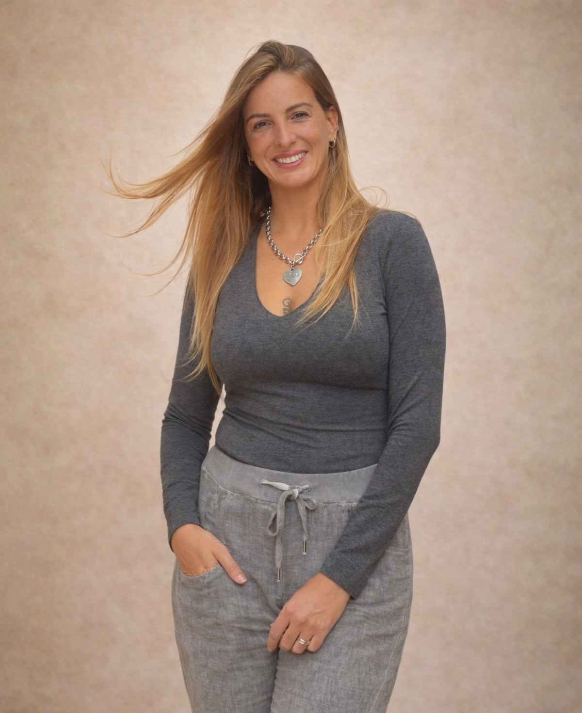 Alternate front view of the Pipa Jersey V-Neck Top in grey showing the slim long sleeves and soft stretch jersey fit.