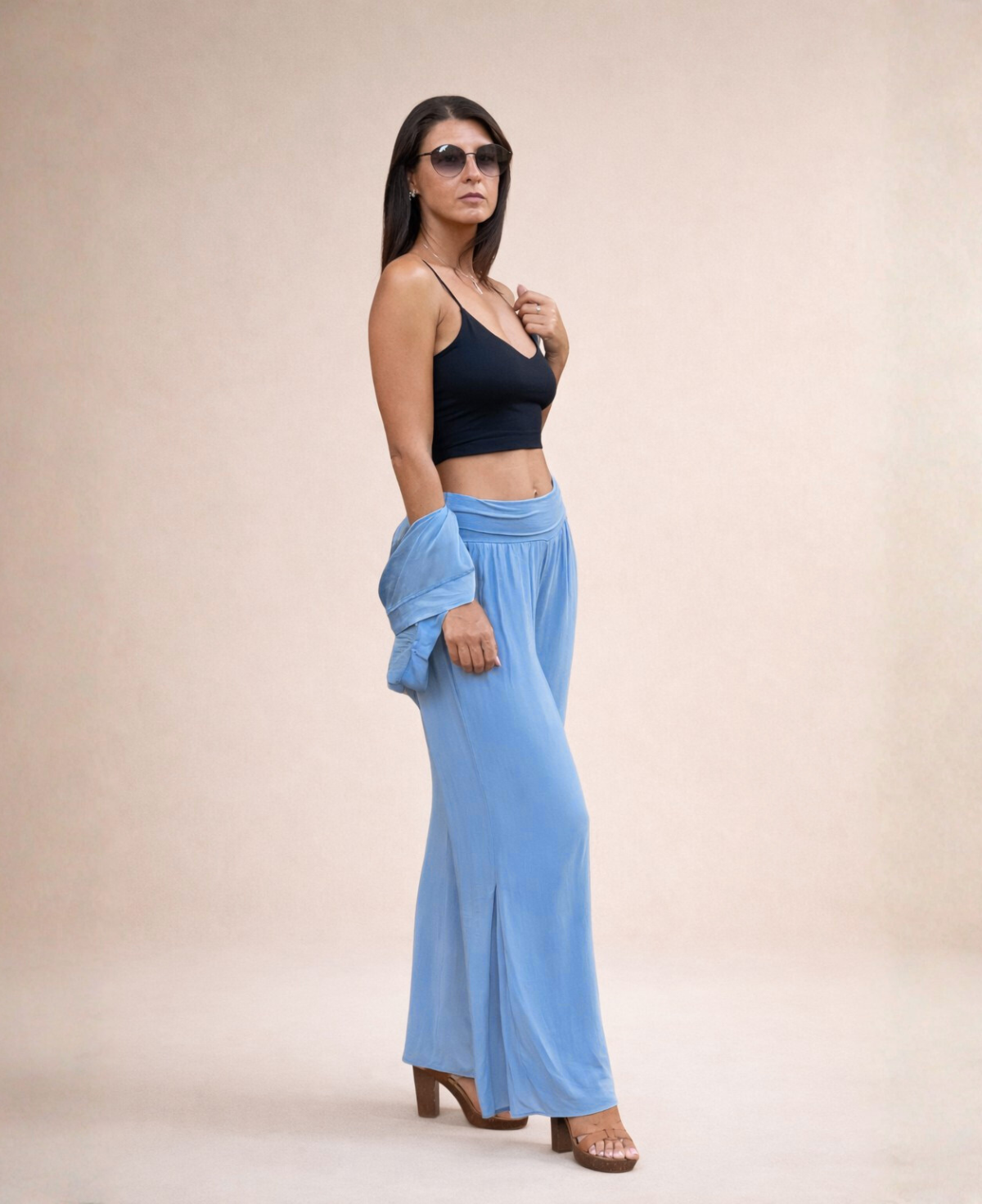 Front angled view of Pippa Silk Pants in Jeans blue silk blend, styled with black cropped tank top and sunglasses in studio.