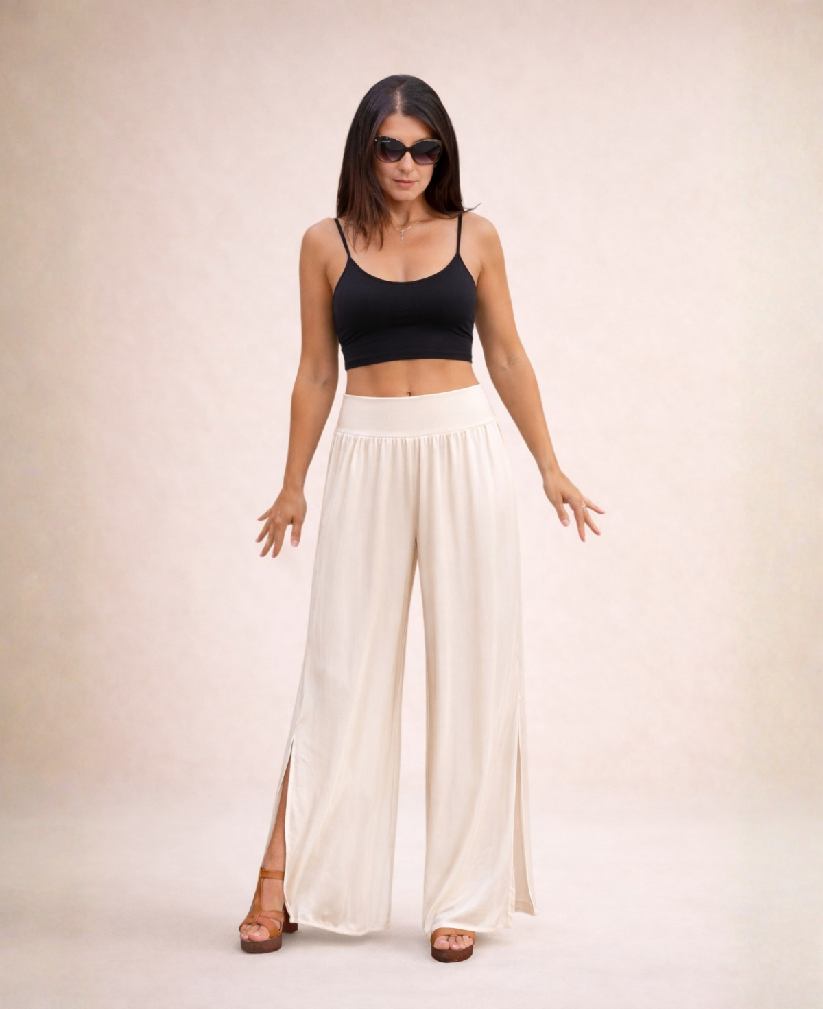 Front view of Pippa Silk Pants in Light Beige silk blend, styled with black cropped tank top and sunglasses in studio.