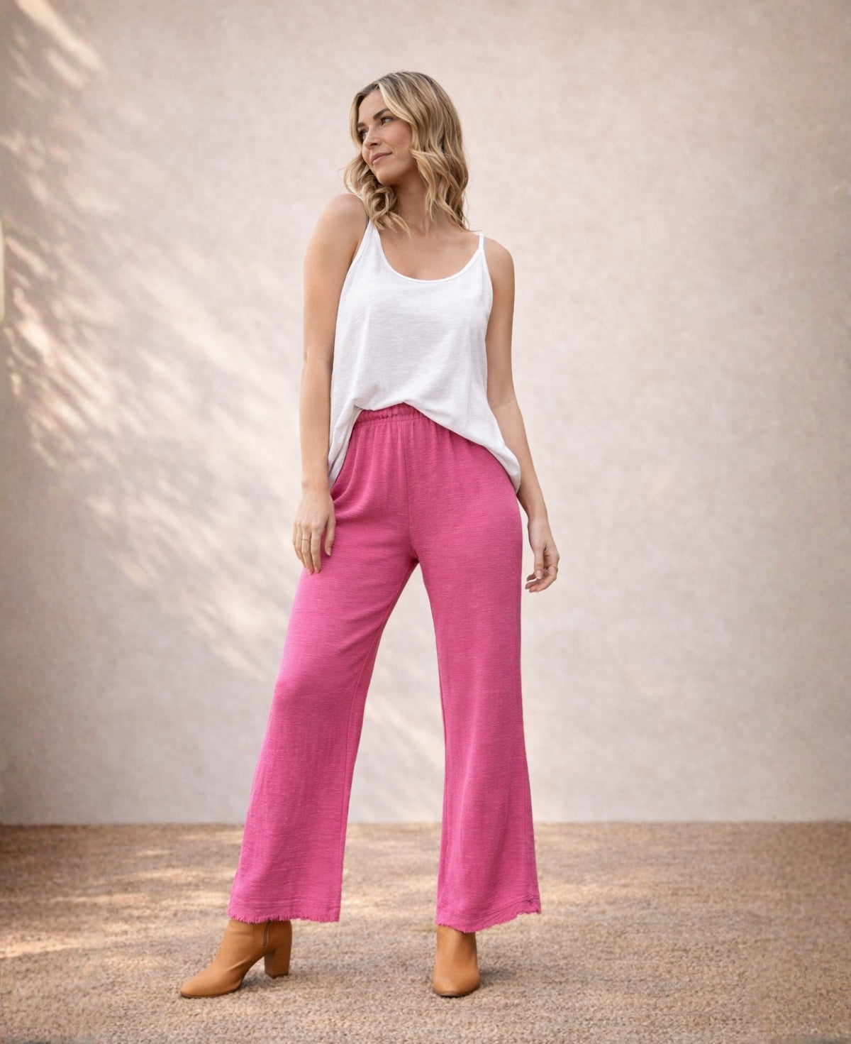 Punto Cotton Pants in fuchsia pink, front view showing elasticated waist, wide leg cotton fit and frayed hem detail.