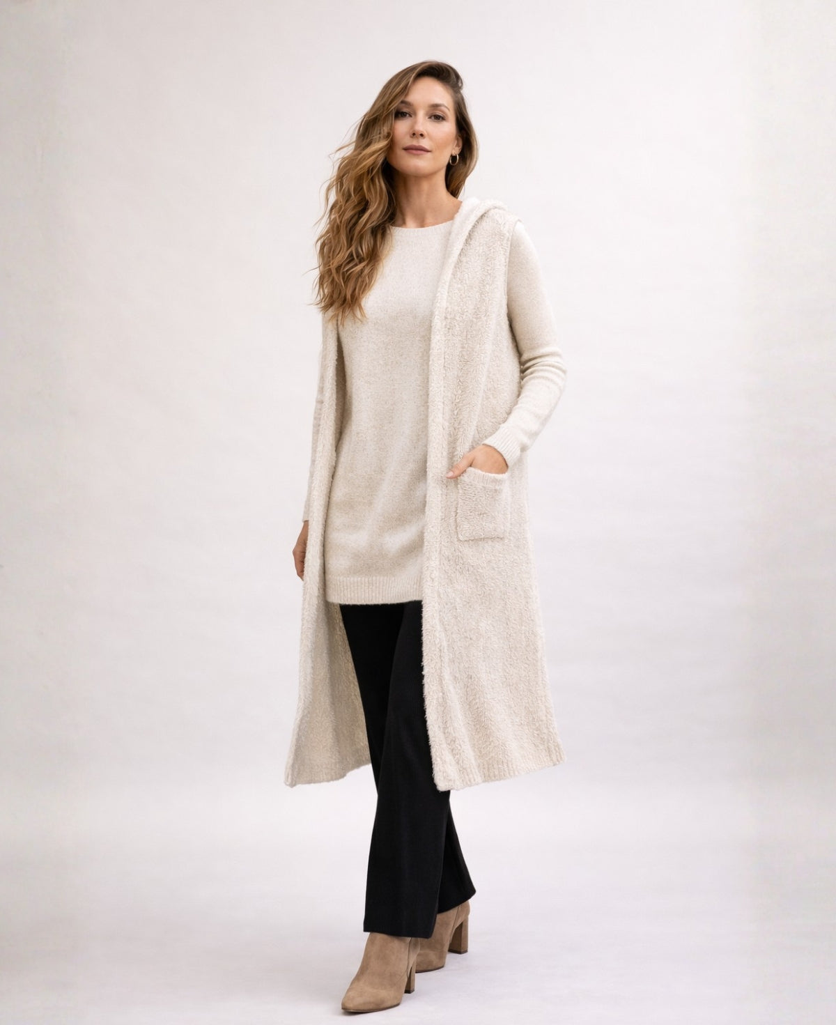 Front angled studio shot of the Rockstar Long Vest in cream styled with the Le Coco Sweater in cream, straight black pants and tan suede ankle boots.