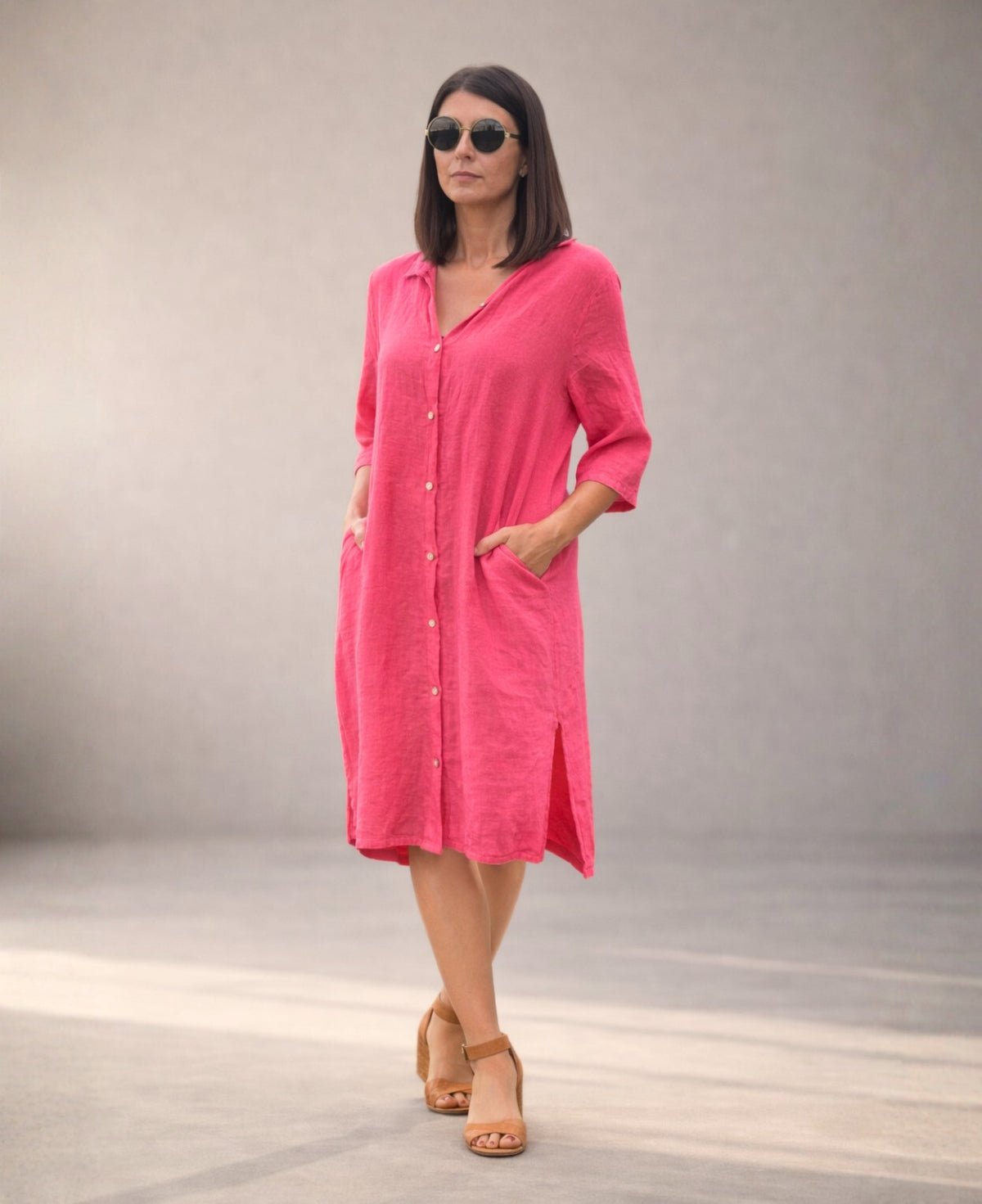 Strawberry pink Samira Linen Shirt-Dress worn buttoned with both hands in side seam pockets, studio view highlighting relaxed fit.