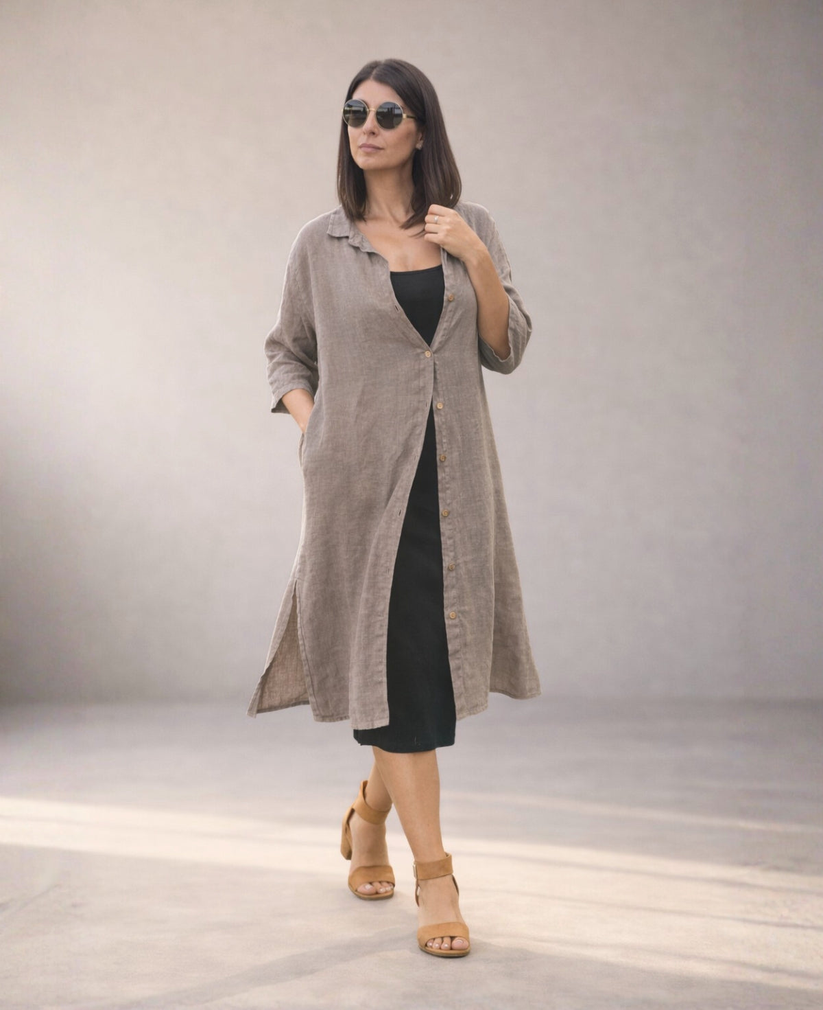 Tope Samira Linen Shirt-Dress styled open over a black jersey dress, walking pose with hand in side pocket showing movement and layering ease.