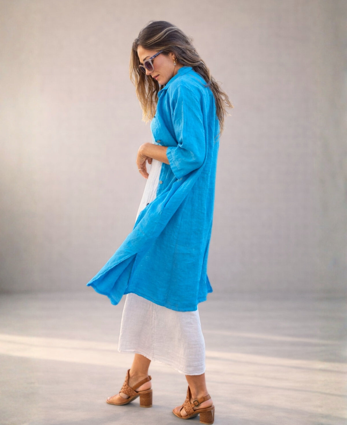 Turquoise Samira Linen Shirt-Dress styled over a longer white linen dress, side studio view showing flow, layering and natural fabric texture.