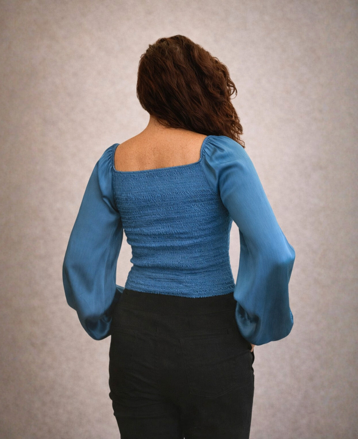 Back view of Shirred Satin Top in Blue Teal featuring shirred panel detail and soft satin long sleeves.