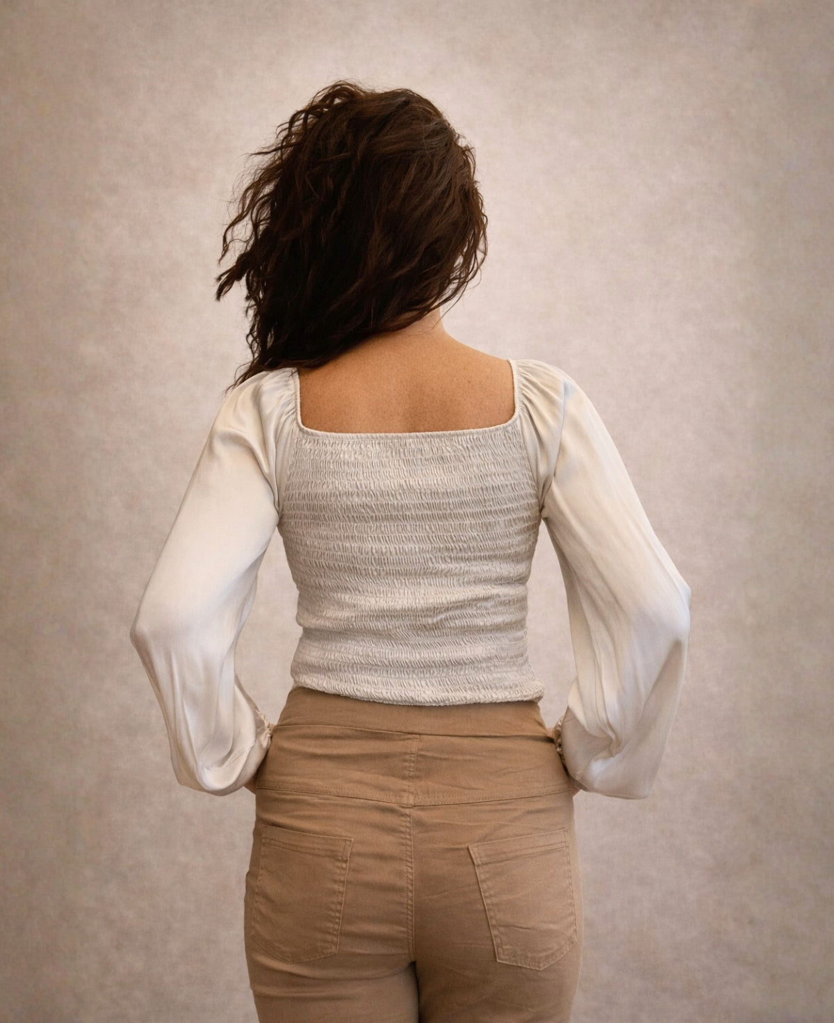 Back view of Shirred Satin Top in Oat showing shirred panel detail and satin long sleeves with soft volume.