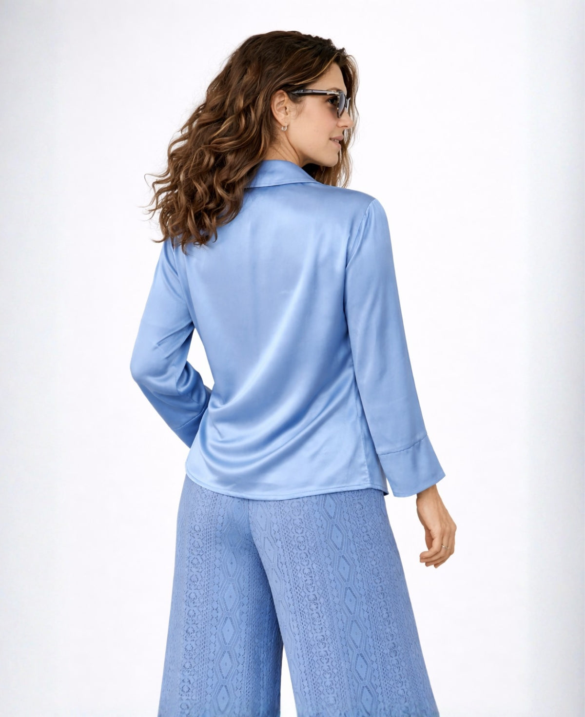 Back angled studio view of the sky blue Coral satin blouse, focusing on the clean back panel and fluid satin movement.