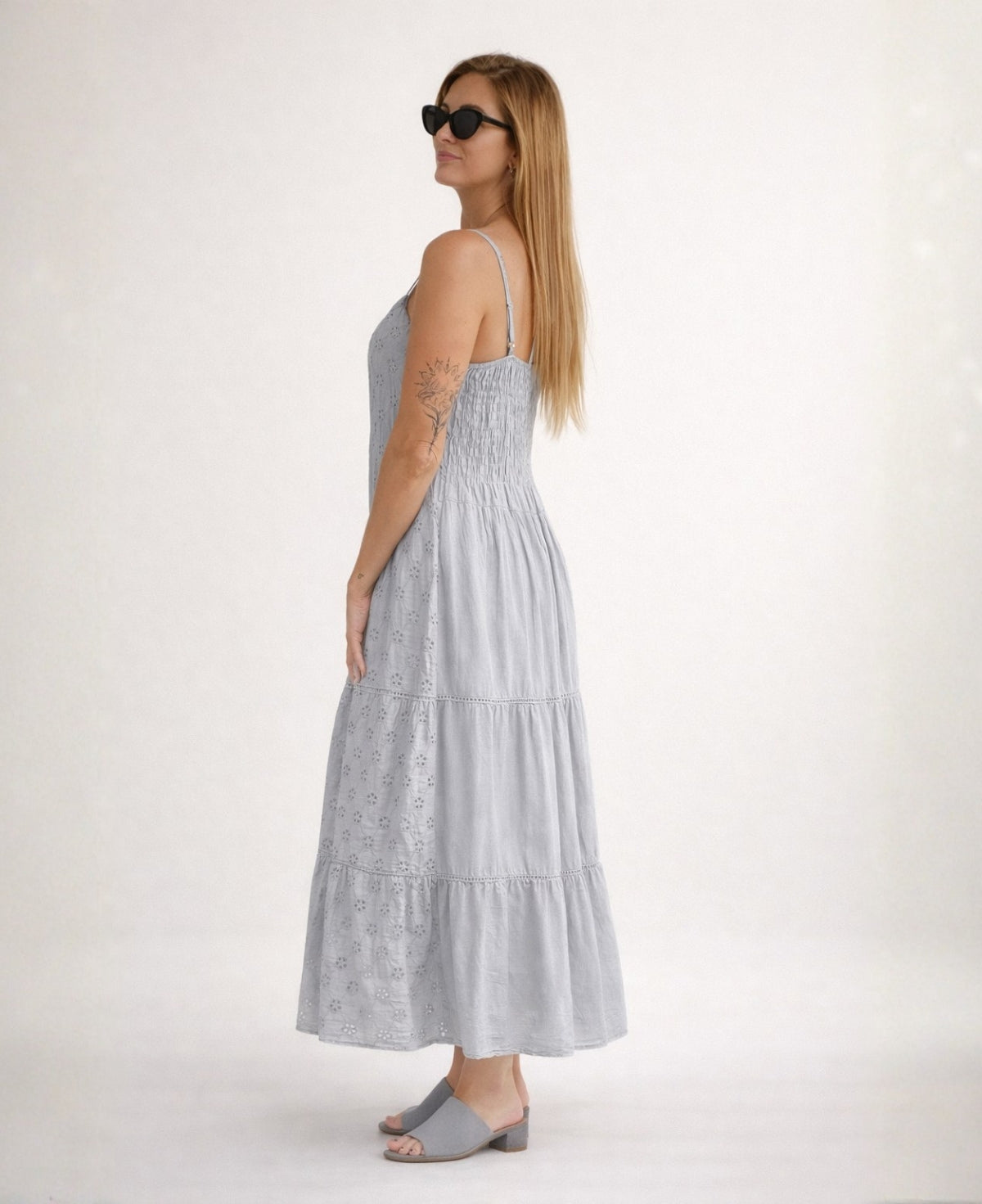 Side view of the Skylar Cotton Eyelet Dress in a silver grey showing cotton eyelet embroidery and tiered maxi skirt in a soft studio setting