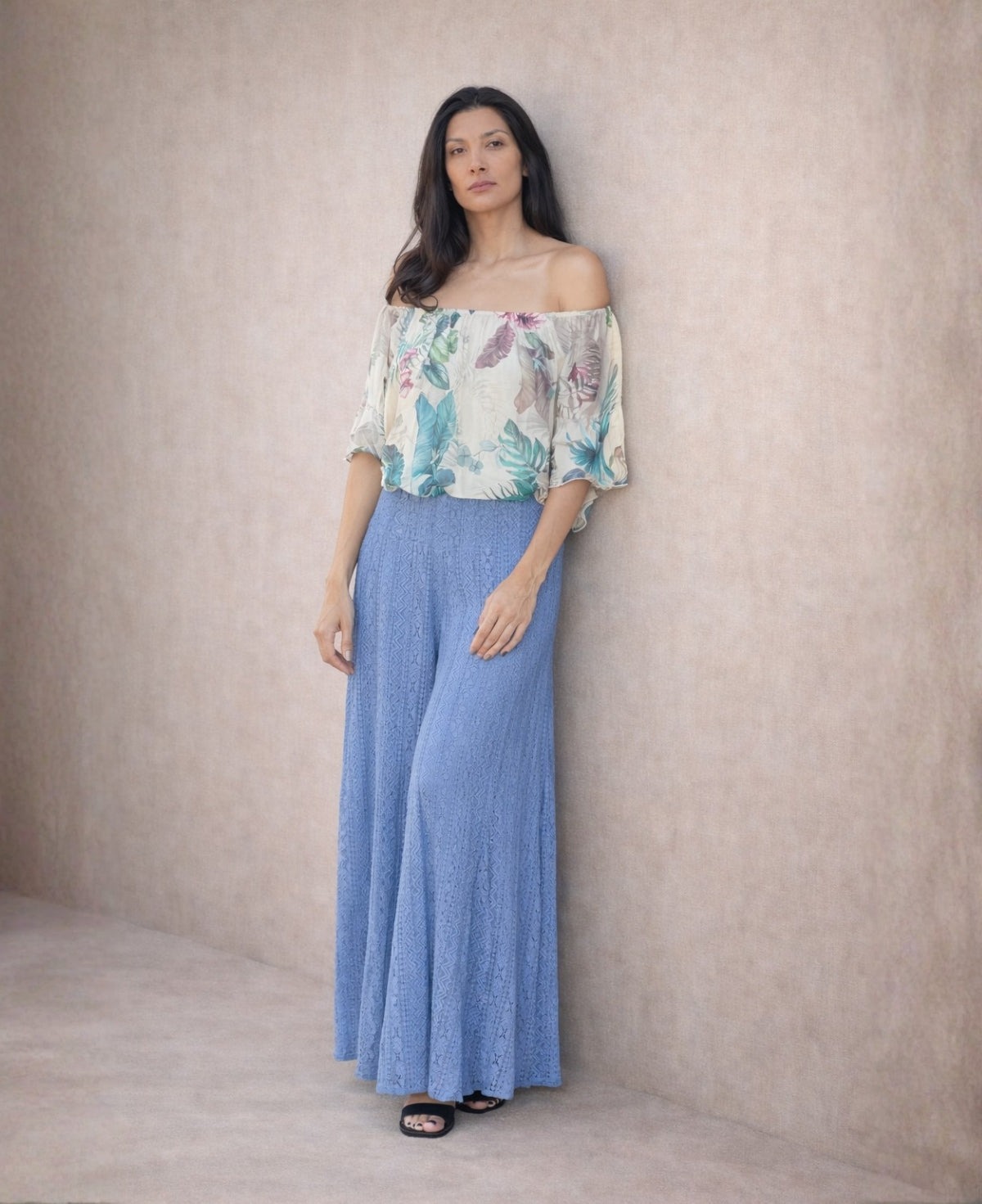 Front view of blue boho lace wide leg pants worn with a floral off-shoulder blouse, shown in a neutral studio background to highlight the fabric texture and elegant movement.
