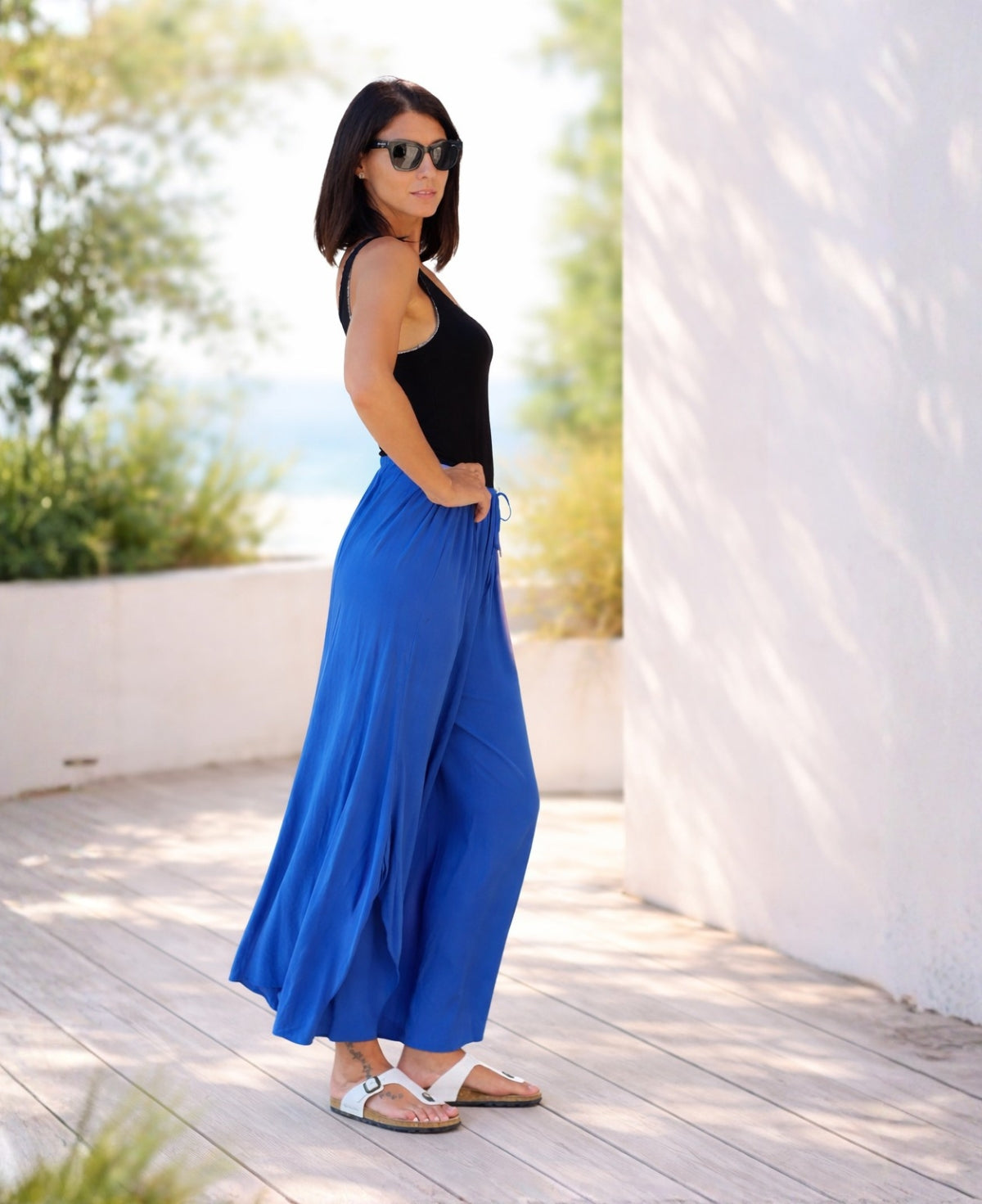 Model wearing cobalt Somma rayon wide leg pants showing side view