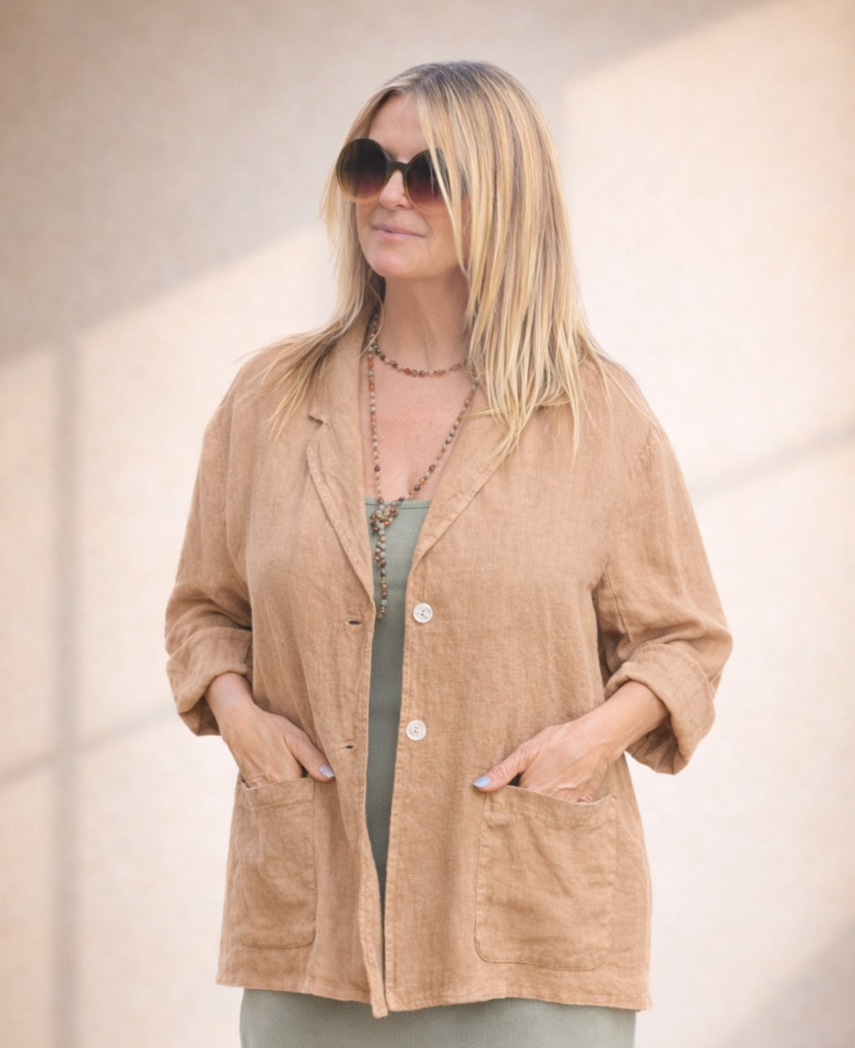 Camel linen blazer with a relaxed silhouette, double-button front, and functional pockets, offering effortless summer sophistication