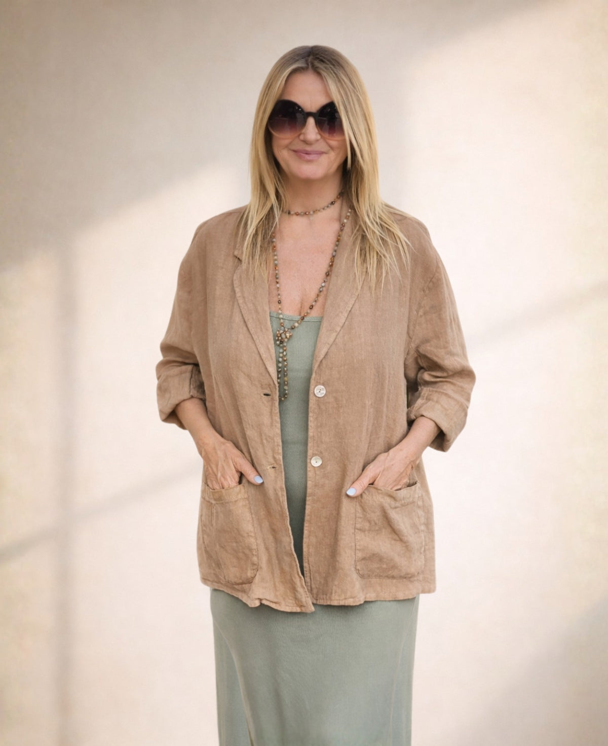 Camel linen blazer with a relaxed silhouette, double-button front, and functional pockets, offering effortless summer sophistication