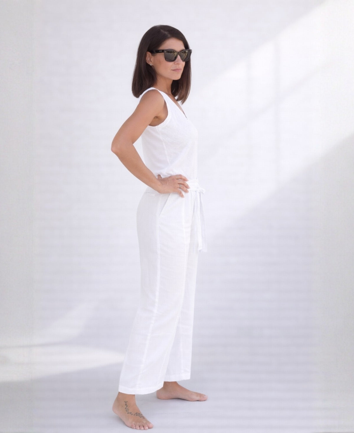 Side view of white linen palazzo pants highlighting straight leg silhouette, soft linen texture, and relaxed fit.