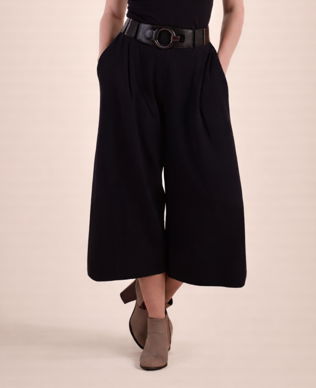 Detail view of black Winter Knit Culottes showing waistband, pleats and wide leg silhouette styled with statement belt and ankle boots.