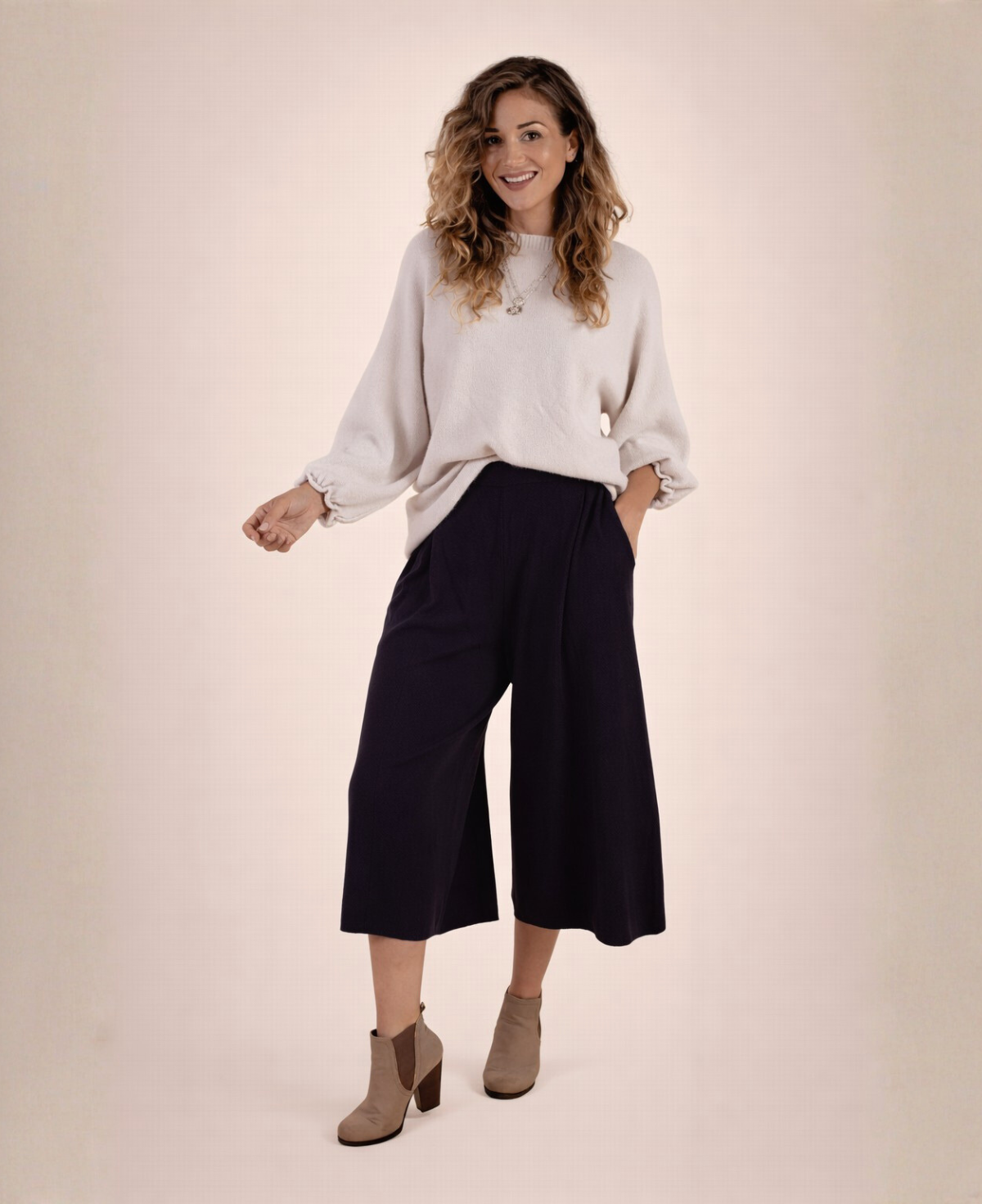 Black Winter Knit Culottes styled with a loose oat knit jumper and ankle boots, model smiling in relaxed full body front view.