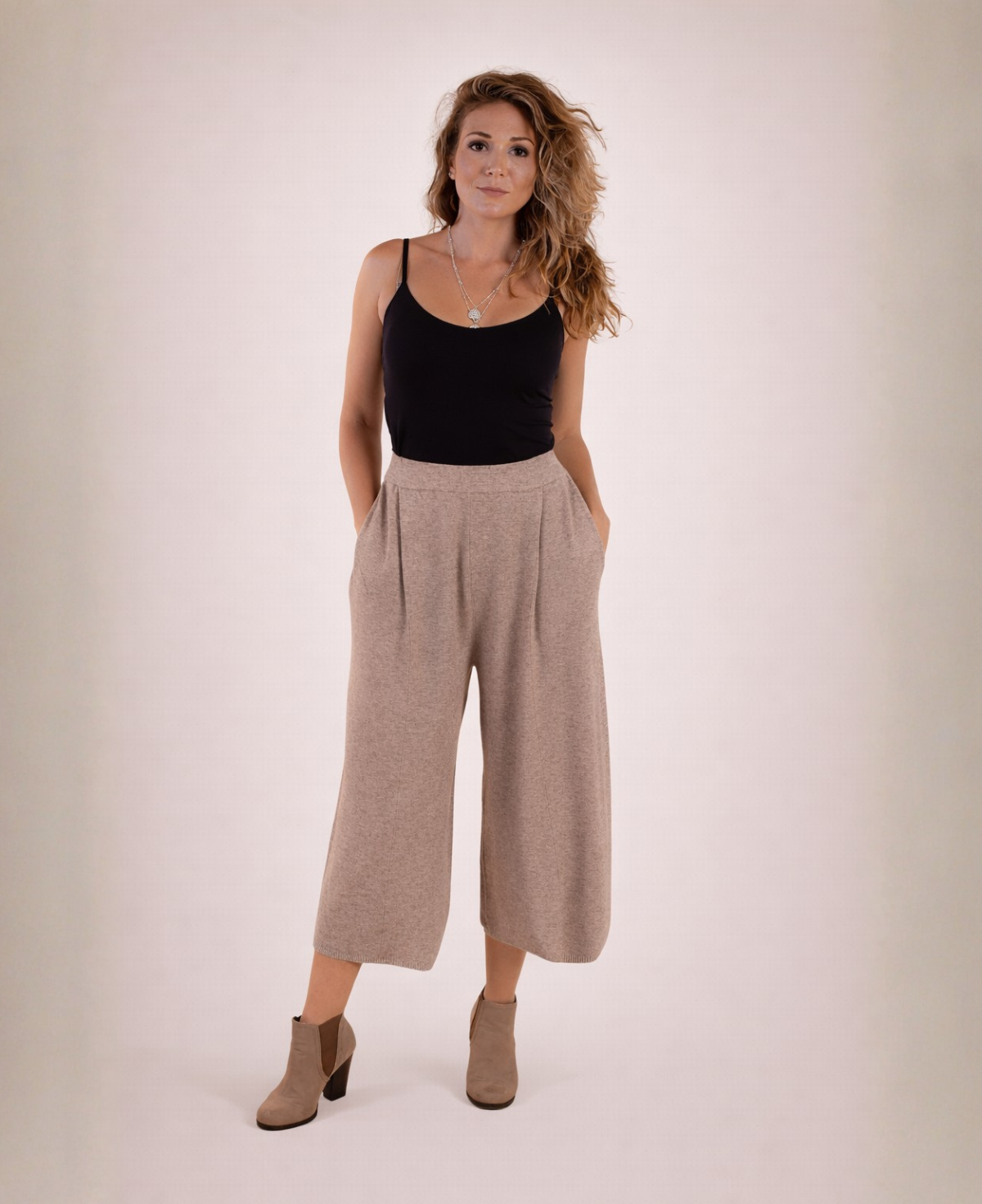 Front view of mocka Winter Knit Culottes worn with a black tank top and ankle boots, model standing with hands in pockets.