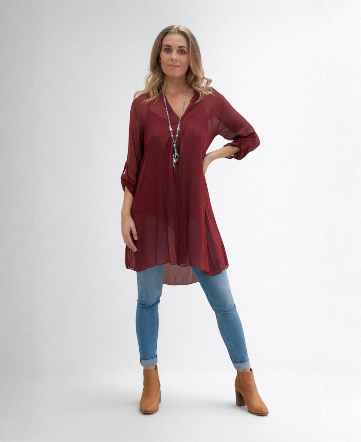 April long silk top in wine colour shown front view with flowy shape and longline silhouette in natural outdoor setting
