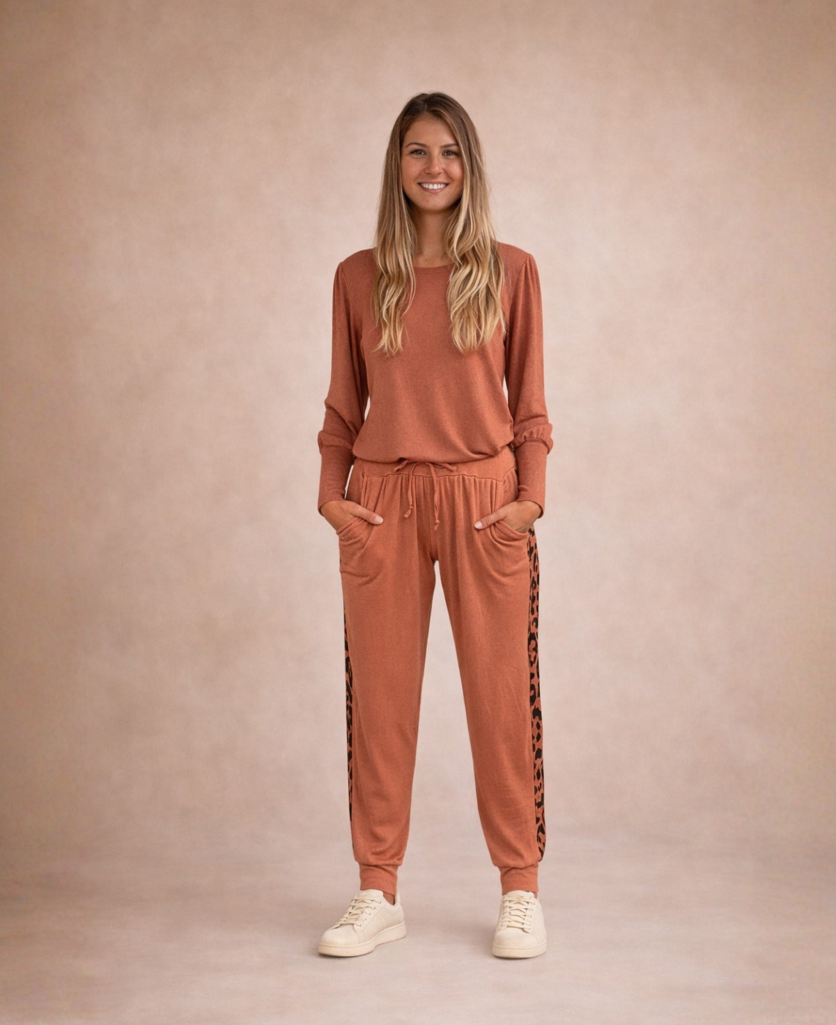 Model wearing Paris Knit Jogger pants in rust front view with drawstring waistband and tapered leg